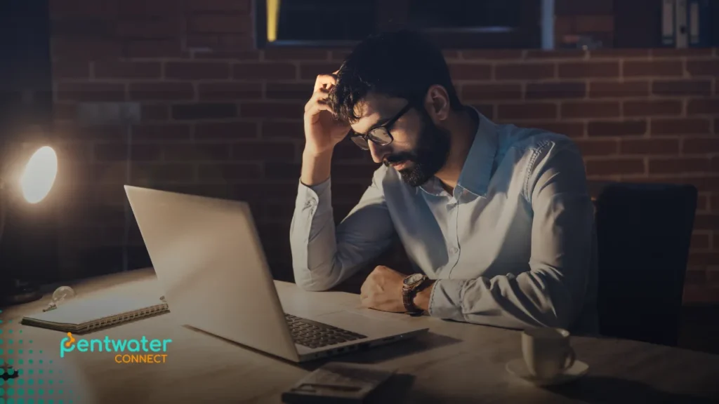 Stressed remote worker at night, overwhelmed by poor outsourcing decisions — illustrating the emotional toll of how to fail at outsourcing.